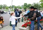 Co-owner Mark Allen (left) and trainer Chip Woolley Jr. hand a rose from Mine That Bird's Kentucky Derby Winner's Garland to fans.