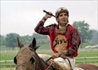 Both rider Willie Martinez and Stars and Glitter are covered in mud after winning the 4th race in front of a record crowd on a rain-soaked opening day at Ellis Park.