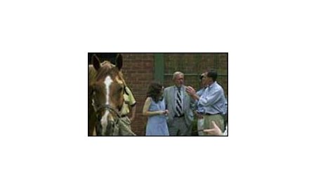 With stallion Old Trieste in the foreground, Kentucky state Rep. Carolyn Belcher, left, and state Sen. Joey Pendleton, center, listen to Jonabell Farm president Jimmy Bell, right.