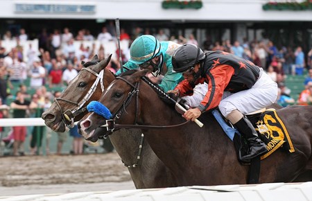 She's Hot Wired #4 (L) and Trevor McCarthy pass 2nd place finisher Bustin Out #6 and Jose Ferrer at the finish line to win the Open Mind Handicap at Monmouth Park in Oceanport, New Jersey on Monday May 30, 2016.