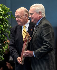 Thomas Gaines, son of John R. Gaines accepts the plaque for his father presented by Edward Bowen at the National Museum of Racing and Hall of Fame induction ceremony held Aug. 4, 2017 at the Fasig Tipton auditorium in Saratoga Springs, N.Y.
