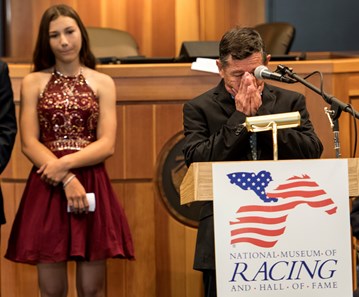 Overcome by emotion, Louie Gomez, father of the late jockey Garrett Gomez gives the acceptance speech for his son as his grand daughter Amanda Gomez looks on at the National Museum of Racing and Hall of Fame induction ceremony held Aug. 4, 2017 at the Fasig Tipton auditorium in Saratoga Springs, N.Y.