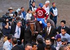 Goncalo Torrealba (left) and Ron Winchell (right) lead Gun Runner into the winner's circle at Gulfstream Park