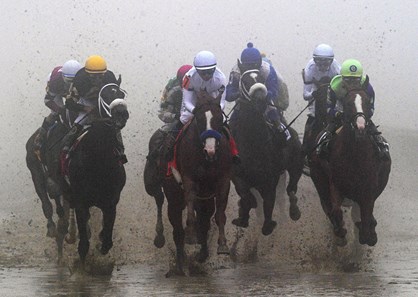 Out of the fog, Justify and Mike Smith lead the way into the clubhouse turn