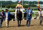 A Raving Beauty's connections, including Sol Kumin (second from left) and Michael Dubb (second from right), lead her to the winner's circle at Belmont Park