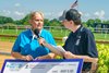 Bessie Gruwell, executive director of the Delaware Thoroughbred Horsemen’s Association, presents a donation check for $15,000 on Autism Day 2025 at Delaware Park