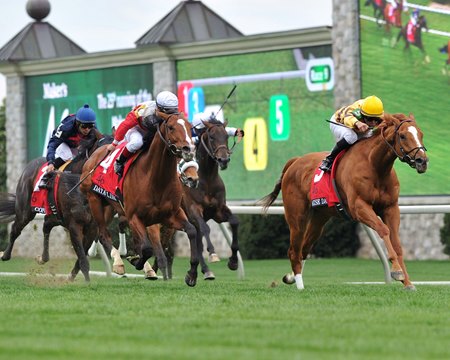 Horses race past the tote board with Trakus chiclits on display at Keeneland