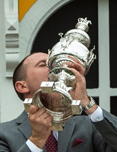 Cloud Computing's trainer kisses the winner's trophy aloft after winning the 142nd running of the Preakness Stakes Saturday May 20, 2017 at Pimlico Race Course in Baltimore, MD.  