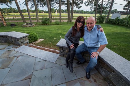 Debbie and Steve Weston in their Saratoga Springs backyard overlooking the Oklahoma Training Track