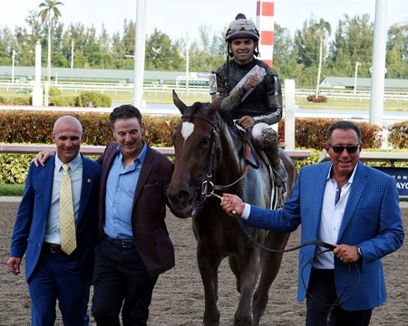 Roddy Valente (right) leads Coach Rocks into the winner's circle after the 2018 Gulfstream Park Oaks at Gulfstream Park