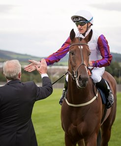 Jockey Danny Tudhope greets trainer Karl Burke after Laurens wins the 2018 Matron Stakes at Leopardstown 