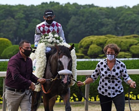 Juan Barajas Saldana and Robin Smullen (right) lead Tiz the Law to the winner's circle after the Belmont Stakes at Belmont Park