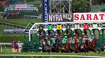 The field for the Bernard Baruch breaks from the gate in real time and on the screen in the background at Saratoga Race Course