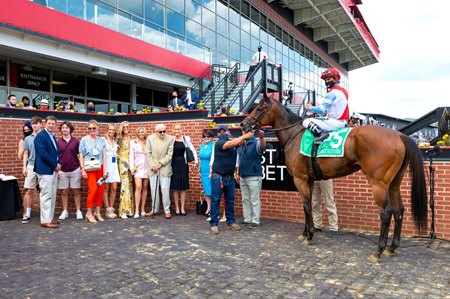 Alex Campbell (tan blazer) joins Mean Mary and connections in the winner's circle after the Gallorette Stakes at Pimlico Race Course 