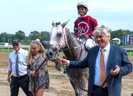 Trainer Steve Asmussen (left) leads Stellar Tap into the winner's circle after the colt's debut victory at Saratoga Race Course