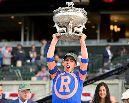 Irad Ortiz Jr. hoists the 2022 Belmont Stakes trophy after his win with Mo Donegal