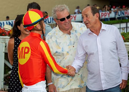 Mike Pegram, center, joins with co-owner Karl Watson, right, in congratulating jockey Juan Hernandez after he guided Cave Rock to victory in the Del Mar Futurity at Del Mar