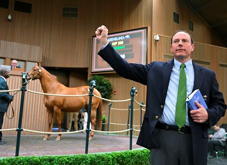 A bid spotter takes a bid during an Thoroughbred auction at Keeneland