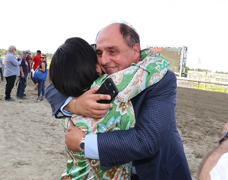 Trainer Antonio Sano hugs Claudia Soto after the Eduardo Soto-owned Il Miracolo's victory in the Smarty Jones Stakes at Parx Racing