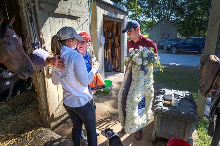 Trainer Brendan Walsh and Walsh assistant Charley Lynch present Melanie Giddings with a wreath of carnations the day after the Test Stakes 