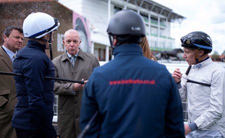 Trainer Karl Burke talks with his riders in April at Newmarket