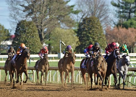 Tyler Gaffalione tries to prevent Sierra Leone (navy silks) from lugging in as he takes the lead in the Blue Grass Stakes at Keeneland