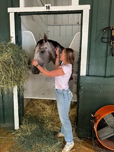 MyRacehorse experience manager Caitlin Dunne shows Preakness Stakes winner Seize the Grey some love at Pimlico Race Course