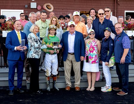 Flavien Prat receives the winner's trophy after Chancer McPatrick's victory in the Hopeful Stakes at Saratoga Race Course. With Prat is trainer Chad Brown (far left) and owner Sean Flanagan (center front row).