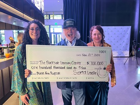 Sierra Leone's co-owner Brook Smith (middle) presents Backside Learning Center director of development Enidza Torres (left) and executive director Sherry Stanley (right) with a $100,000 check for the Purses For a Purpose program