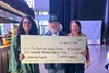 Co-owner Brook Smith (middle) presents Backside Learning Center executive director Sherry Stanley (right) and director of development Enidza Torres (left) with a $100,000 check following Sierra Leone’s victory in the Breeders’ Cup Classic