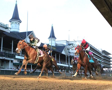 Laughing Boy (red cap) is awarded victory in the Claiming Crown Jewel after the disqualification of Surface to Air (black cap) at Churchill Downs