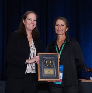 Kelley Stobie (right), co-founder and executive director of Caribbean Thoroughbred Aftercare, accepts the American Association of Equine Practitioners A. Gary Lavin Equine Welfare Award