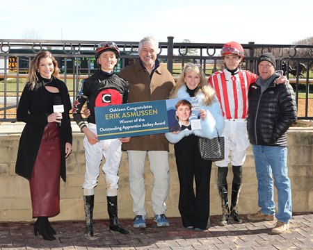 Erik Asmussen (second from left) is joined by his parents, Steve and Julie Asmussen, and others in a presentation at Oaklawn Park