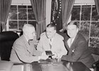 Photograph of President Truman at his desk in the Oval Office, receiving his annual pass to National Football League games from Bert Bell, Commissioner of the National Football League (center), and George Marshall, owner of the Washington Redskins.