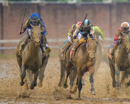 Sovereignty (left) moves past Journalism (striped cap) on his way to victory in the Kentucky Derby at Churchill Downs