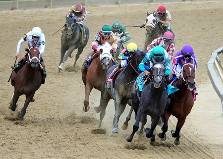 Journalism and jockey Umberto Rispoli (burgundy and white checkered sleeves) battle for space in the Preakness Stakes at Pimlico Race Course