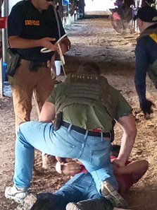 ICE agents detain a worker June 17 at Delta Downs