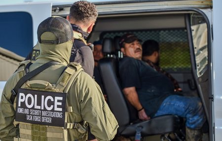 U.S. Immigration and Customs Enforcement agents load alleged illegal immigrant backstretch workers into a van at Delta Downs Racetrack