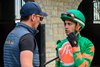 Flavien Prat in race 3 turf on number 10 Good Game talks with trainer Rodolphe Brisset (greenwhite circle AR on orange ball, green cap) in the paddock before the race at Keeneland on April 12, 2025, in Lexington, Ky. 