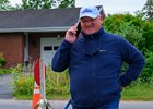 Kenny McPeek on the phone and smiliing as he crosses the street to his barn. 
Training scenes from Saratoga Racecourse on Aug. 21, 2025.