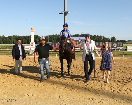 Joe Anzalone, second from right, leads Fort Washington into the winner's circle after the Arlington Million at Colonial Downs