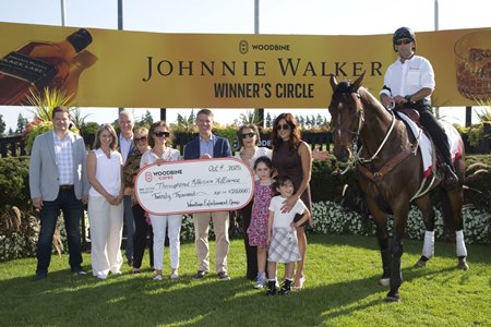 Michael Copeland (center) makes a check presentation to Thoroughbred Aftercare Alliance