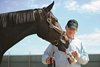 Zenyatta licks an empty cup from trainer John Shirreffs at Hollywood Park.