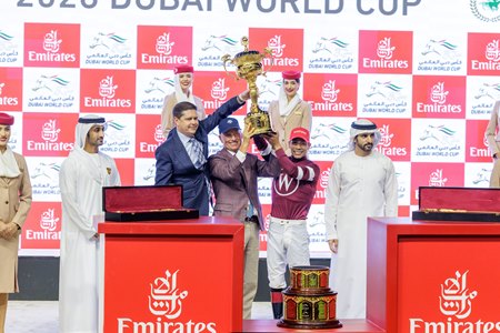 Jockey Jose Ortiz hoists the Dubai World Cup trophy alongside owner Ron Winchell (left) and assistant trainer Scott Blasi (middle) at Meydan Racecourse
