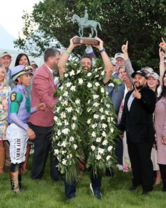 Co-owner Mike Repole holds up the trophy after Renegade's win in the Arkansas Derby at Oaklawn Park