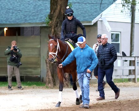 Trainer Todd Pletcher (right) walks to the Churchill Downs track with Renegade