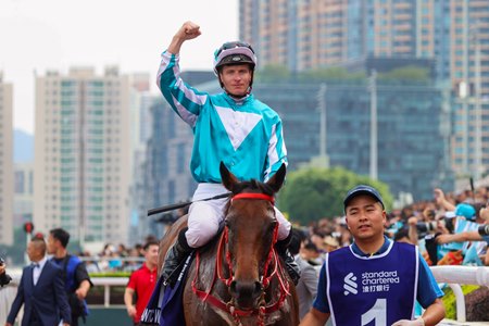 James McDonald celebrates aboard Romantic Warrior after their victory in the Champions & Chater Cup at Sha Tin Racecourse