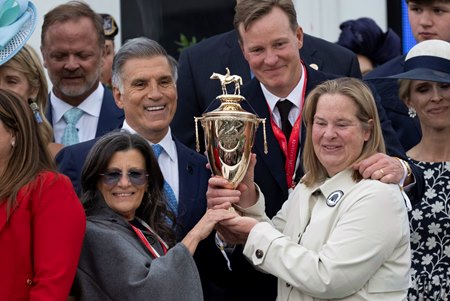 (L-R: top) Co-owners Vincent Viola and Ogden Phipps II (L-R: bottom) Teresa Viola and Daisy Phipps Pulito hold the trophy in the winner’s circle after winning the Kentucky Derby