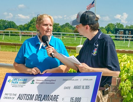 Bessie Gruwell, executive director of the Delaware Thoroughbred Horsemen’s Association, presents a donation check for $15,000 on Autism Day 2025 at Delaware Park