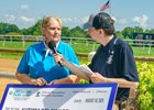Bessie Gruwell, executive director of the Delaware Thoroughbred Horsemen’s Association, presents a donation check for $15,000 on Autism Day 2025 at Delaware Park